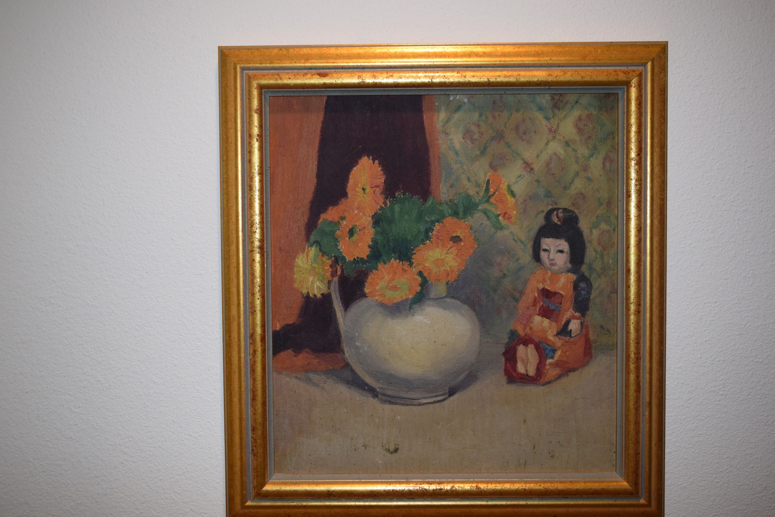 Framed still-life painting with orange flowers and a seated doll